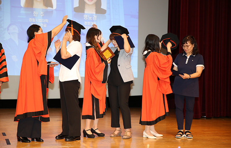 동국대 졸업생들이 가족에게 학사모를 씌워주고 있다. 