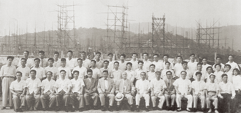 명진관 건설 현장을 배경으로 찍은 학교 관계자 기념 사진(1955년). 가운데 모자를 손에 쥐고 있는 분이 백성욱 총장이다.